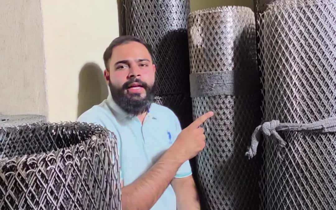 Shop owner showing rolls of expanded metal mesh