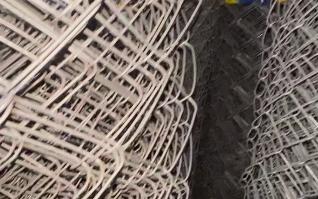 Galvanised chain link rolls stacked for farm fencing