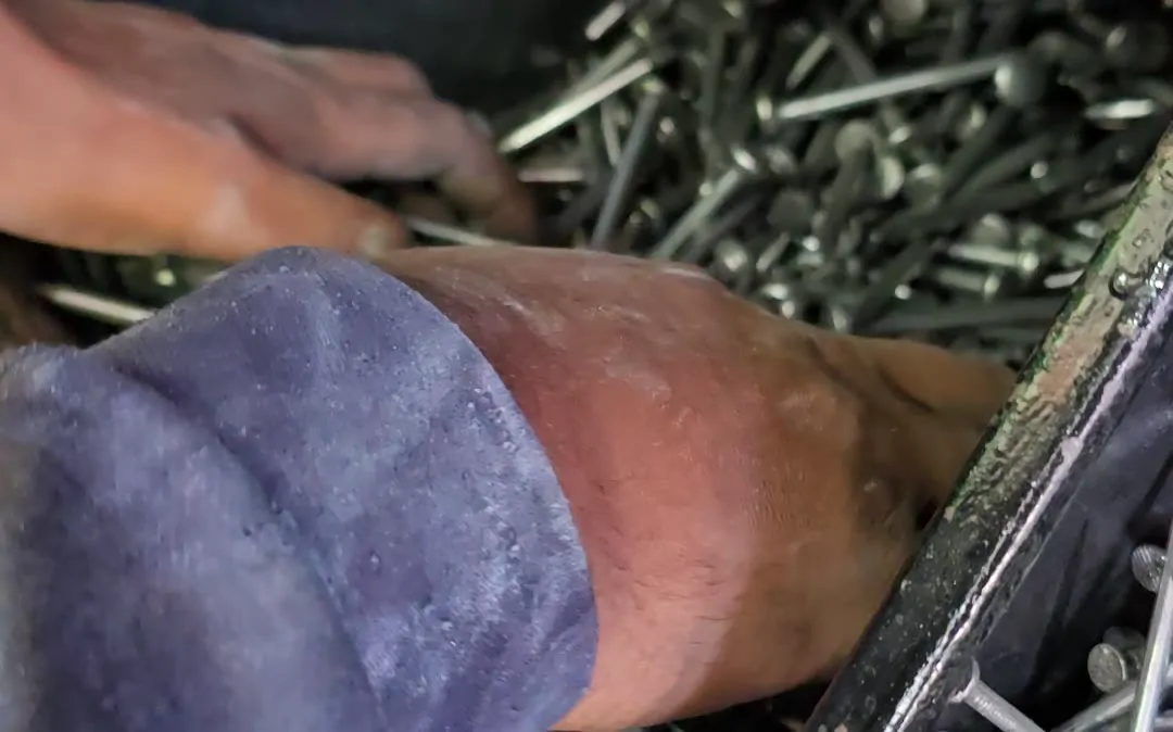 Hand sorting wire nails from a bin
