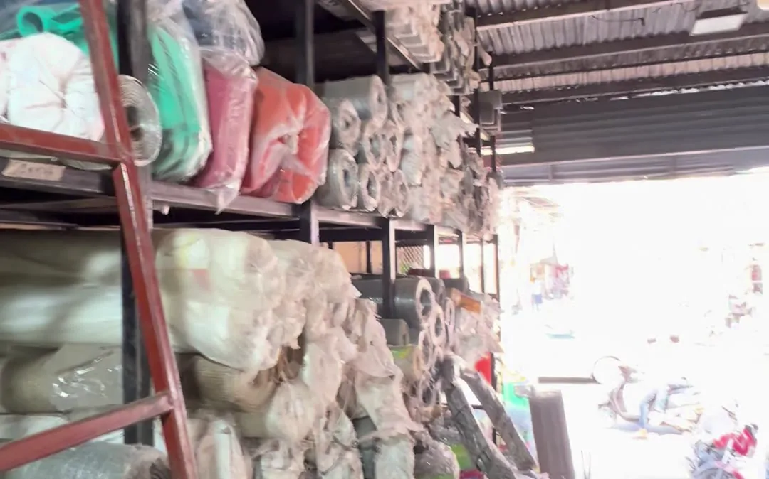 Wire mesh rolls racked on high shelves in the Siyaganj godown