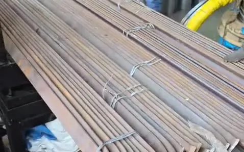 Bundles of TMT bars tied and laid out beside a coil of wire