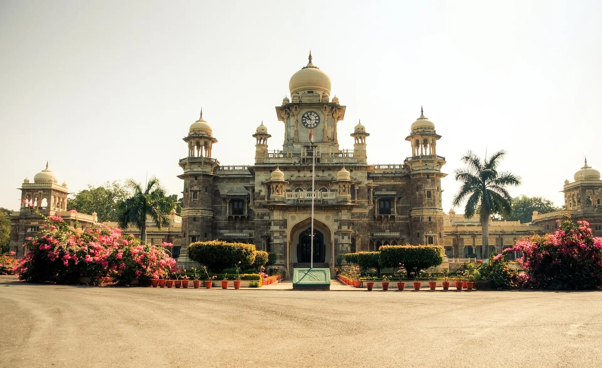 The front of Daly College, Indore, with its clock tower, domes and flowering bougainvillea