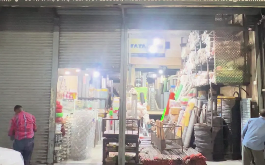 Siyaganj lane with shop shutters and goods vehicles