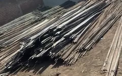 Bundled steel sections laid out on the ground for counting