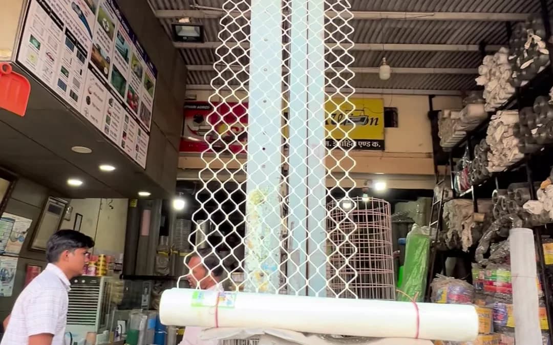 Chain link rolls stored upright near the shop entrance
